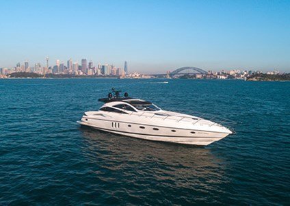 A corporate charter boat cruises on the waters against a backdrop of the Harbour Bridge & Sydney skyline
