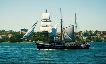 The elegant three-masted schooner looks breathtakingly beautiful against the harbour backdrop.