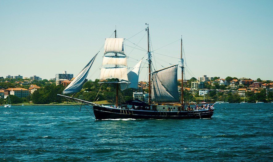 The elegant three-masted schooner looks breathtakingly beautiful against the harbour backdrop.